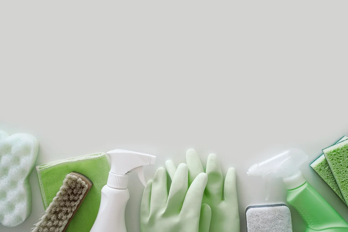 Green cleaning supplies on a light surface